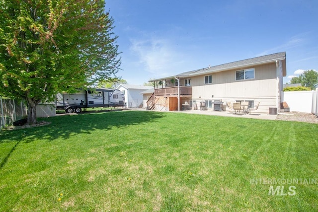 back of house with a deck, stairway, a fenced backyard, a patio area, and a lawn
