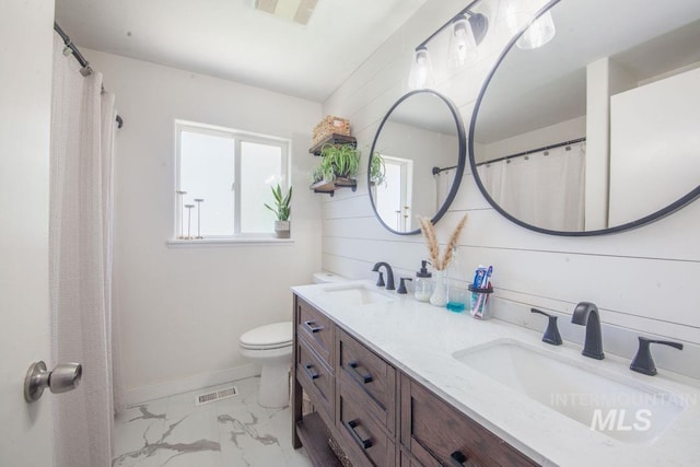 bathroom featuring toilet, visible vents, a sink, and marble finish floor
