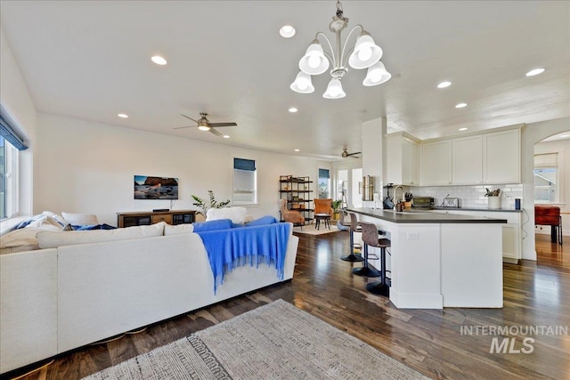 kitchen with open floor plan, white cabinetry, dark wood finished floors, and a breakfast bar area