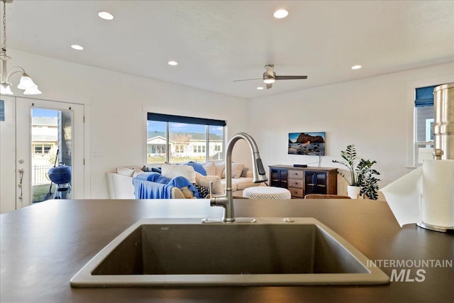 kitchen with recessed lighting, a sink, a ceiling fan, open floor plan, and decorative light fixtures