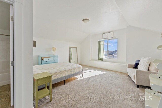 carpeted bedroom featuring vaulted ceiling, visible vents, and baseboards