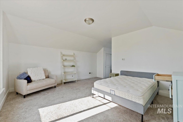 carpeted bedroom with baseboards and vaulted ceiling