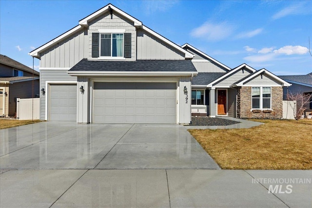 craftsman-style house with a garage, concrete driveway, fence, board and batten siding, and a front yard