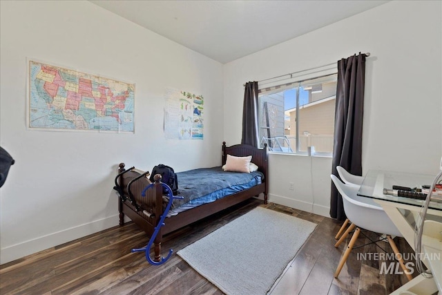 bedroom with baseboards and wood finished floors