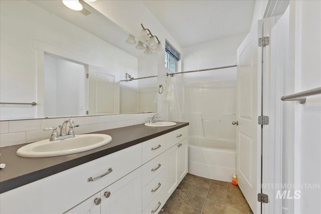 full bath with double vanity, a sink, and shower / bathtub combination