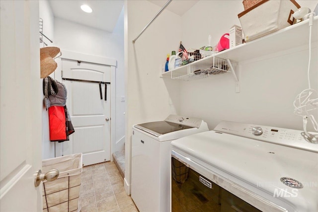 clothes washing area featuring laundry area, independent washer and dryer, and light tile patterned floors