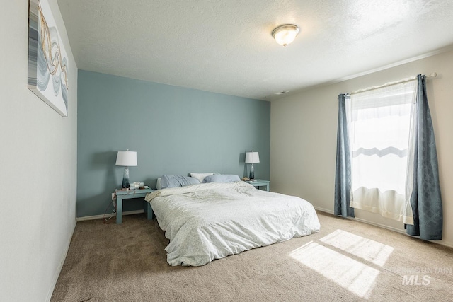 carpeted bedroom featuring baseboards and a textured ceiling