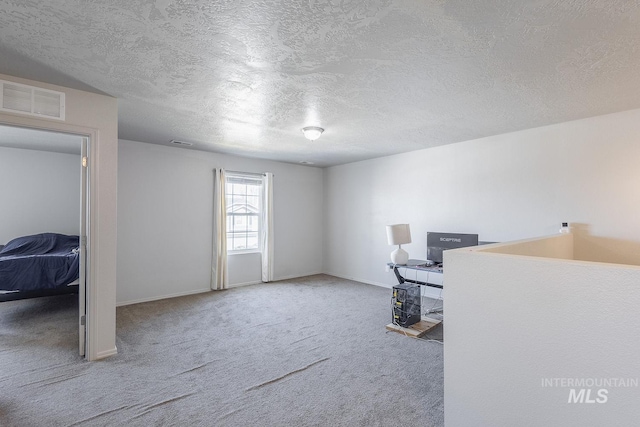 interior space with baseboards, visible vents, and a textured ceiling