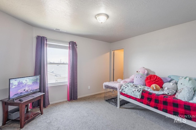 bedroom featuring baseboards, visible vents, a textured ceiling, and carpet