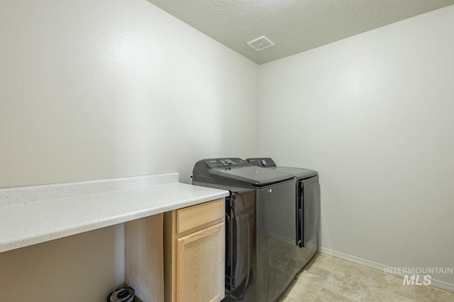 laundry area featuring visible vents, a textured ceiling, baseboards, laundry area, and washing machine and clothes dryer