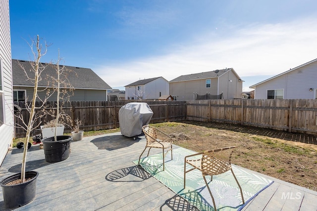 view of patio featuring a wooden deck, a grill, and a fenced backyard