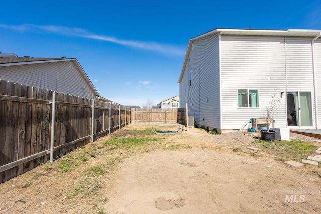 rear view of house with central air condition unit and a fenced backyard