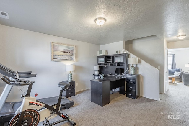 carpeted home office with visible vents, baseboards, and a textured ceiling