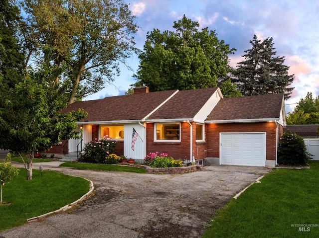 1600 E Victory Rd, Boise, ID 83706 - ranch-style home with asphalt driveway, a garage, a chimney, a lawn, and brick siding