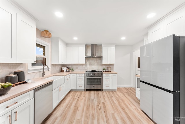 1600 E Victory Rd, Boise, ID 83706 - kitchen with high end range, freestanding refrigerator, wall chimney exhaust hood, dishwashing machine, and light countertops