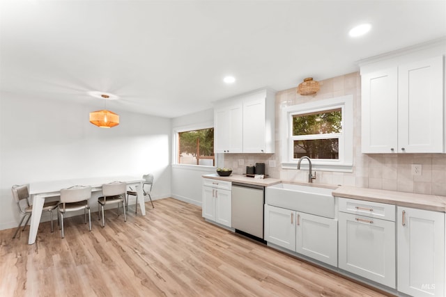 1600 E Victory Rd, Boise, ID 83706 - kitchen with stainless steel dishwasher, a sink, backsplash, baseboards, and light countertops