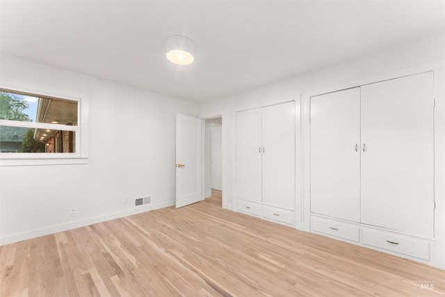 1600 E Victory Rd, Boise, ID 83706 - unfurnished bedroom featuring two closets, wood finished floors, and baseboards