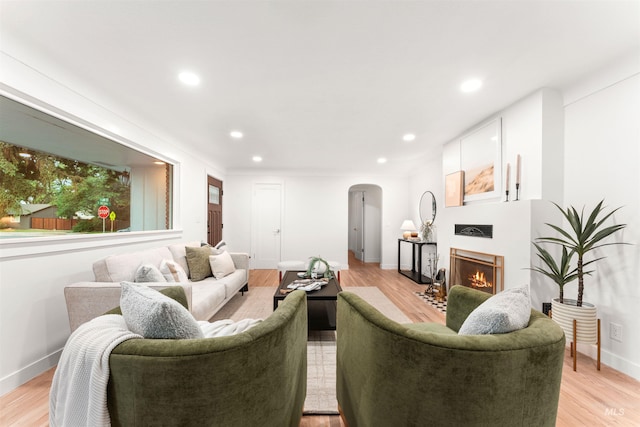 1600 E Victory Rd, Boise, ID 83706 - living area with arched walkways, a lit fireplace, light wood finished floors, baseboards, and recessed lighting