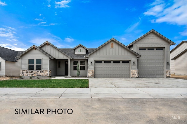 9887 W Snow Wolf Ln, Star, ID 83669 - view of front facade with board and batten siding, stone siding, an attached garage, concrete driveway, and a front lawn