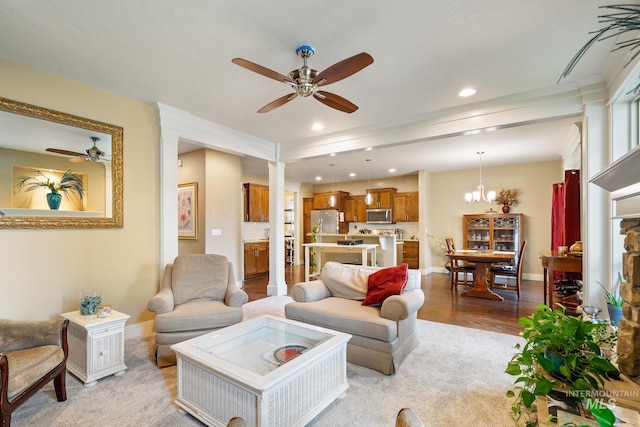 living room with recessed lighting, light wood-style flooring, baseboards, and ceiling fan with notable chandelier