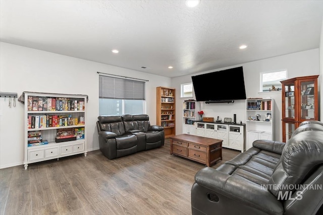 living area with recessed lighting, a healthy amount of sunlight, baseboards, and dark wood-style flooring