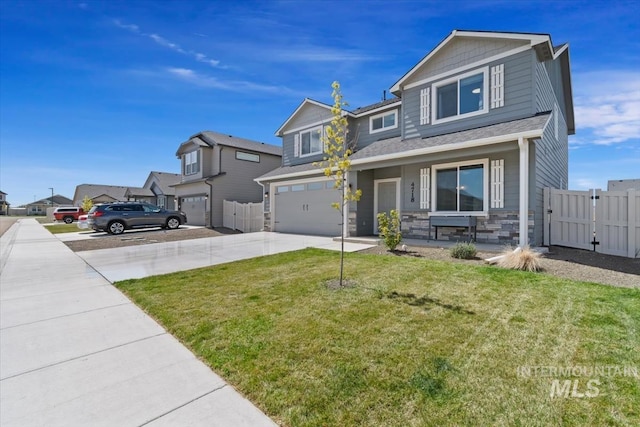 view of front facade featuring fence, concrete driveway, stone siding, a front yard, and a garage