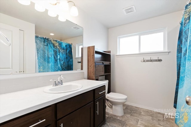 bathroom featuring baseboards, visible vents, vanity, and toilet