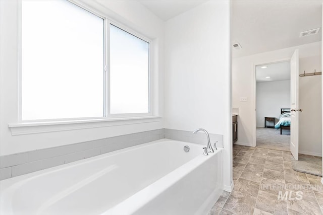full bathroom with stone finish floor, visible vents, vanity, connected bathroom, and a garden tub