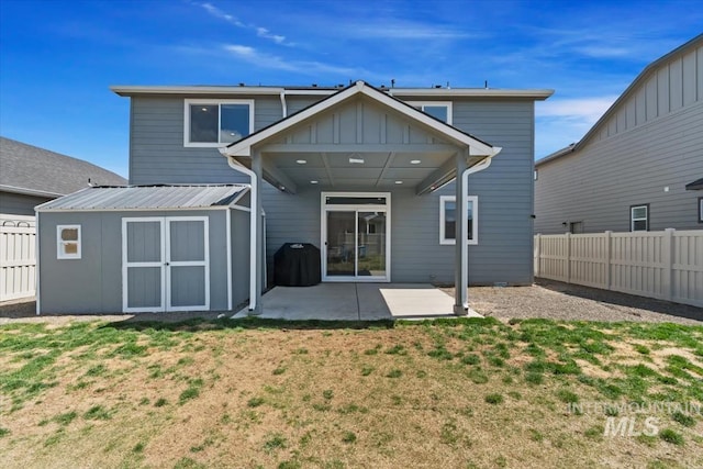 rear view of property featuring a fenced backyard, a patio area, a lawn, and a storage unit
