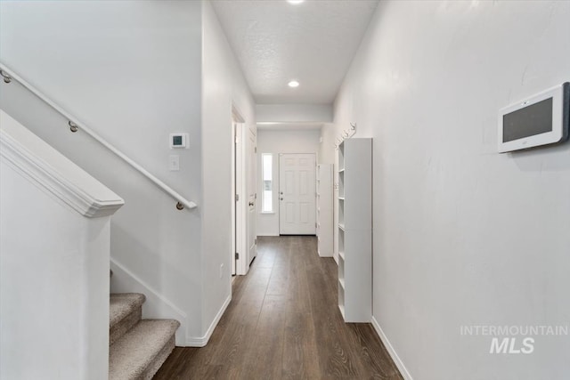 corridor featuring baseboards, recessed lighting, stairway, and dark wood finished floors