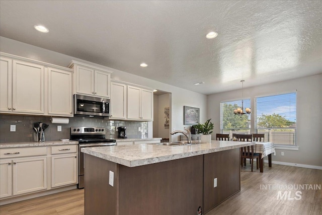 1123 Drexel Hill Ave, Caldwell, ID 83605 - kitchen featuring stainless steel appliances, a sink, light wood finished floors, light countertops, and tasteful backsplash