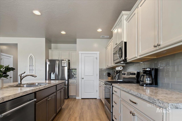 1123 Drexel Hill Ave, Caldwell, ID 83605 - kitchen with stainless steel appliances, a sink, light countertops, light wood-style floors, and recessed lighting