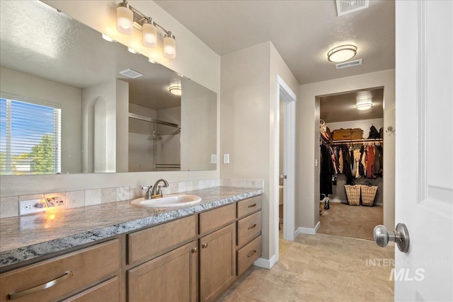 1123 Drexel Hill Ave, Caldwell, ID 83605 - bathroom with vanity, a spacious closet, an enclosed shower, and baseboards