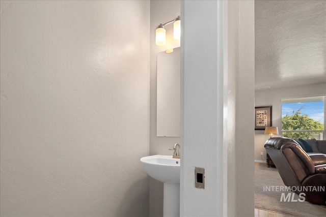 1123 Drexel Hill Ave, Caldwell, ID 83605 - bathroom with a textured wall, a sink, baseboards, and a textured ceiling