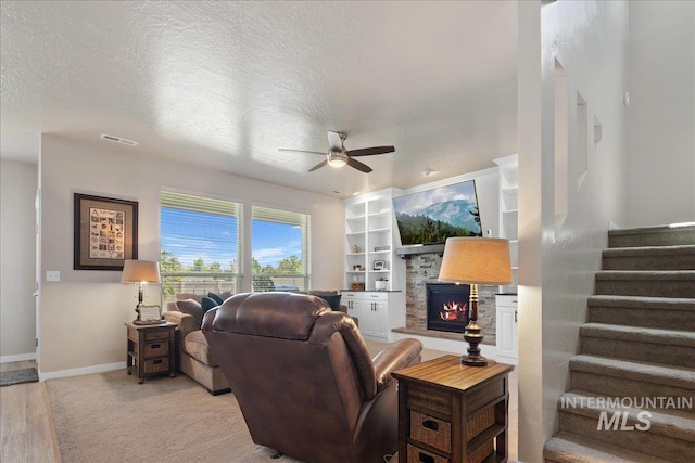 1123 Drexel Hill Ave, Caldwell, ID 83605 - living area with a stone fireplace, ceiling fan, stairs, a textured ceiling, and baseboards