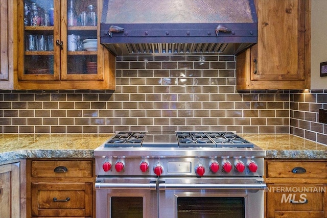 370 Blackhawk Lake Dr, Mccall, ID 83638 - kitchen featuring range with two ovens, extractor fan, brown cabinets, and decorative backsplash