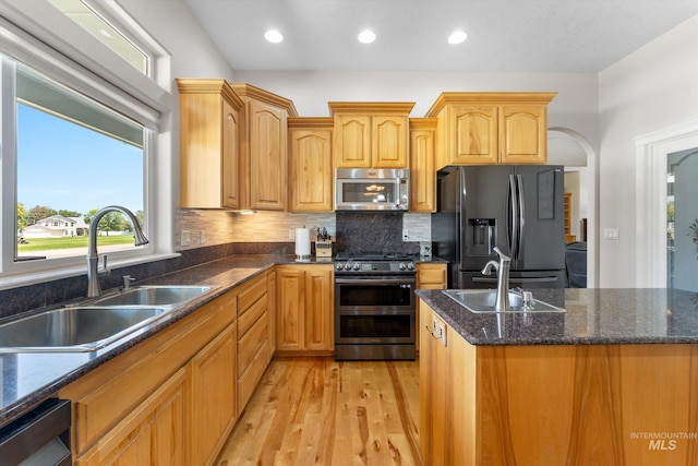 4019 E Man O War Dr, Nampa, ID 83686 - kitchen with stainless steel appliances, arched walkways, plenty of natural light, light wood finished floors, and recessed lighting