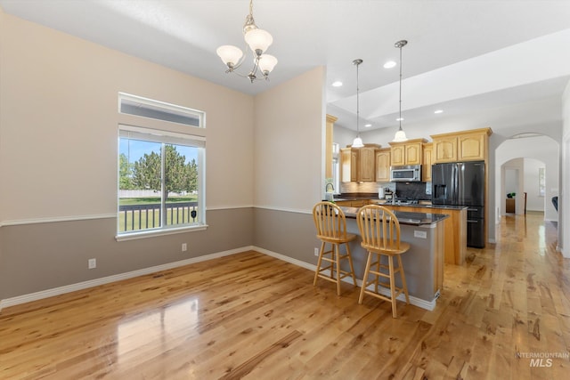 4019 E Man O War Dr, Nampa, ID 83686 - kitchen with stainless steel appliances, arched walkways, light wood-style floors, a chandelier, and recessed lighting