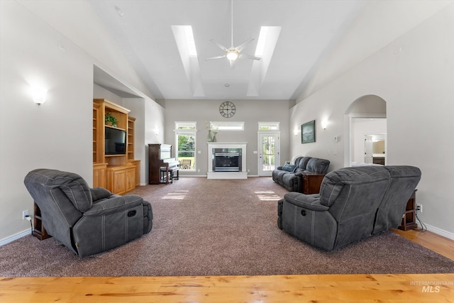 4019 E Man O War Dr, Nampa, ID 83686 - living area featuring a ceiling fan, high vaulted ceiling, a glass covered fireplace, a skylight, and arched walkways