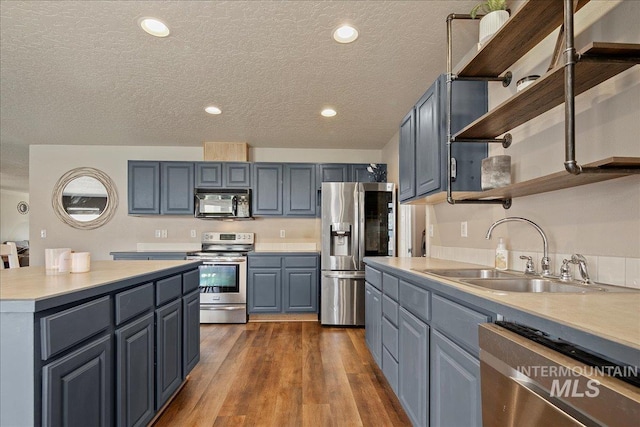 9308 W Rustica Dr, Boise, ID 83709 - kitchen featuring appliances with stainless steel finishes, open shelves, light countertops, dark wood-type flooring, and a textured ceiling