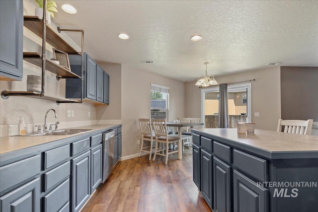 9308 W Rustica Dr, Boise, ID 83709 - kitchen featuring open shelves, a chandelier, dark wood-style flooring, a textured ceiling, and dishwasher