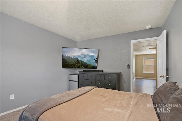 9308 W Rustica Dr, Boise, ID 83709 - bedroom with freestanding refrigerator and a textured ceiling