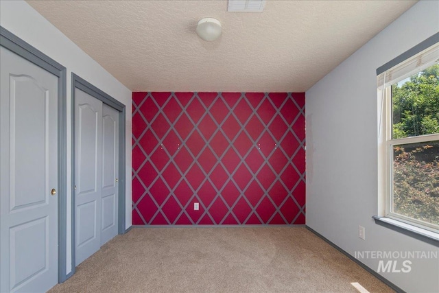 9308 W Rustica Dr, Boise, ID 83709 - unfurnished bedroom with carpet flooring, a textured ceiling, and an accent wall