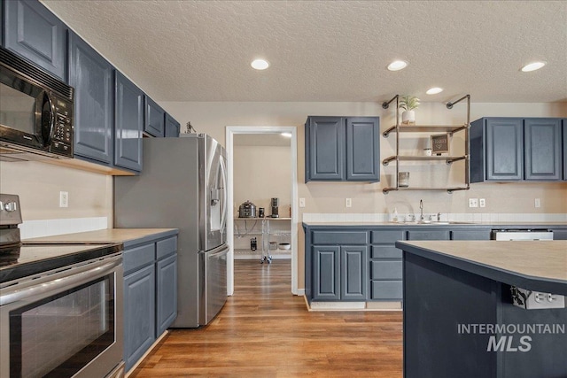 9308 W Rustica Dr, Boise, ID 83709 - kitchen with appliances with stainless steel finishes, a textured ceiling, light wood-style flooring, light countertops, and recessed lighting