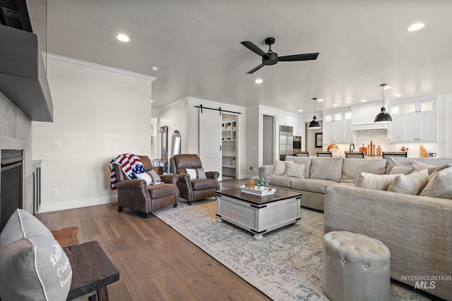 2245 N Burnam Ave, Star, ID 83669 - living room with a barn door, a ceiling fan, recessed lighting, wood finished floors, and ornamental molding