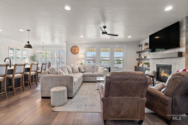 2245 N Burnam Ave, Star, ID 83669 - living room with crown molding, ceiling fan, wood-type flooring, and a tile fireplace