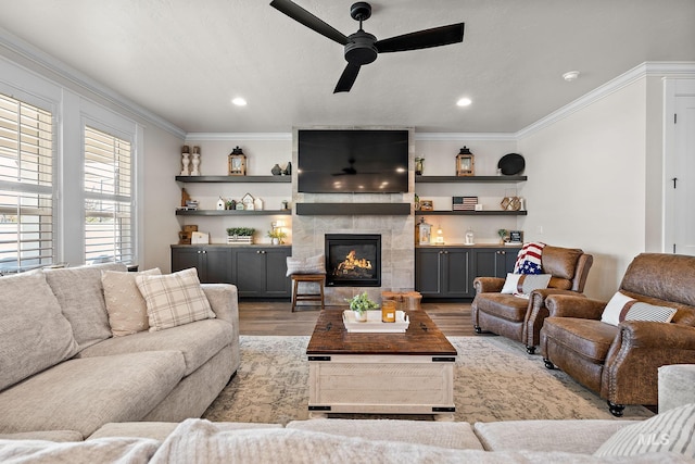 2245 N Burnam Ave, Star, ID 83669 - living room featuring crown molding, light wood-style floors, recessed lighting, a tiled fireplace, and a ceiling fan