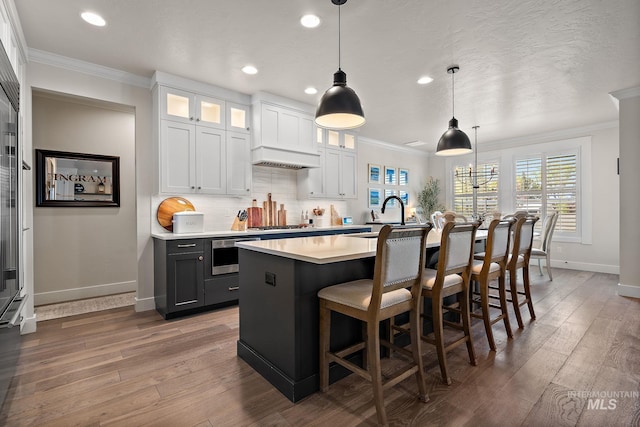2245 N Burnam Ave, Star, ID 83669 - kitchen featuring baseboards, ornamental molding, hardwood / wood-style flooring, and light countertops