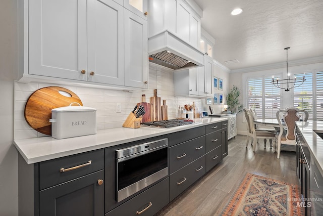 2245 N Burnam Ave, Star, ID 83669 - kitchen with crown molding, glass insert cabinets, baseboards, white cabinetry, and a chandelier