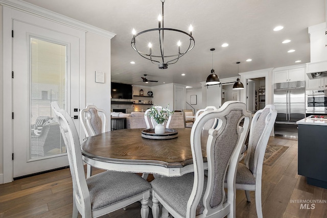 2245 N Burnam Ave, Star, ID 83669 - dining space featuring crown molding, wood-type flooring, ceiling fan with notable chandelier, and recessed lighting